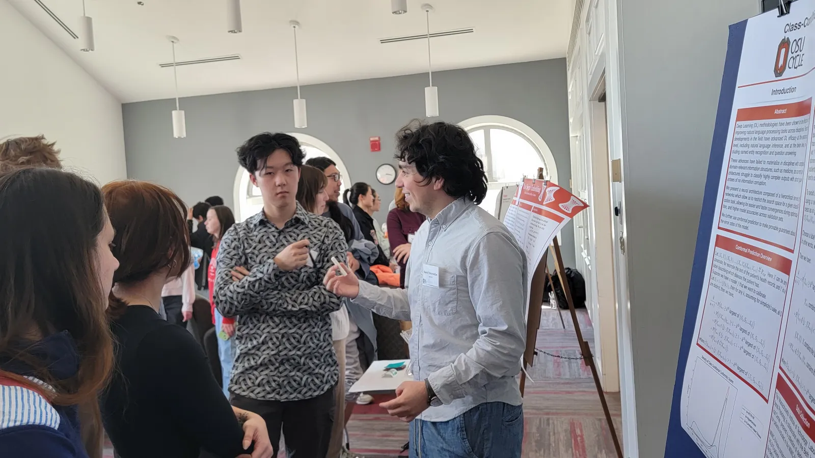 students and professors looking at an OSU Cycle poster at the 2024 Cycle conference