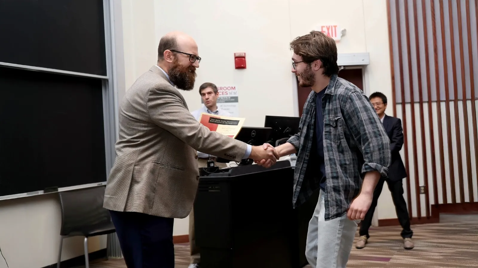 Student and professor shaking hands