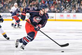 Hockey player with stick on ice wearing Blue Jackets uniform