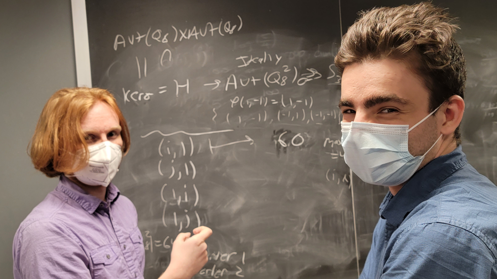 mentoring group smiling in front of a blackboard in 2022 class