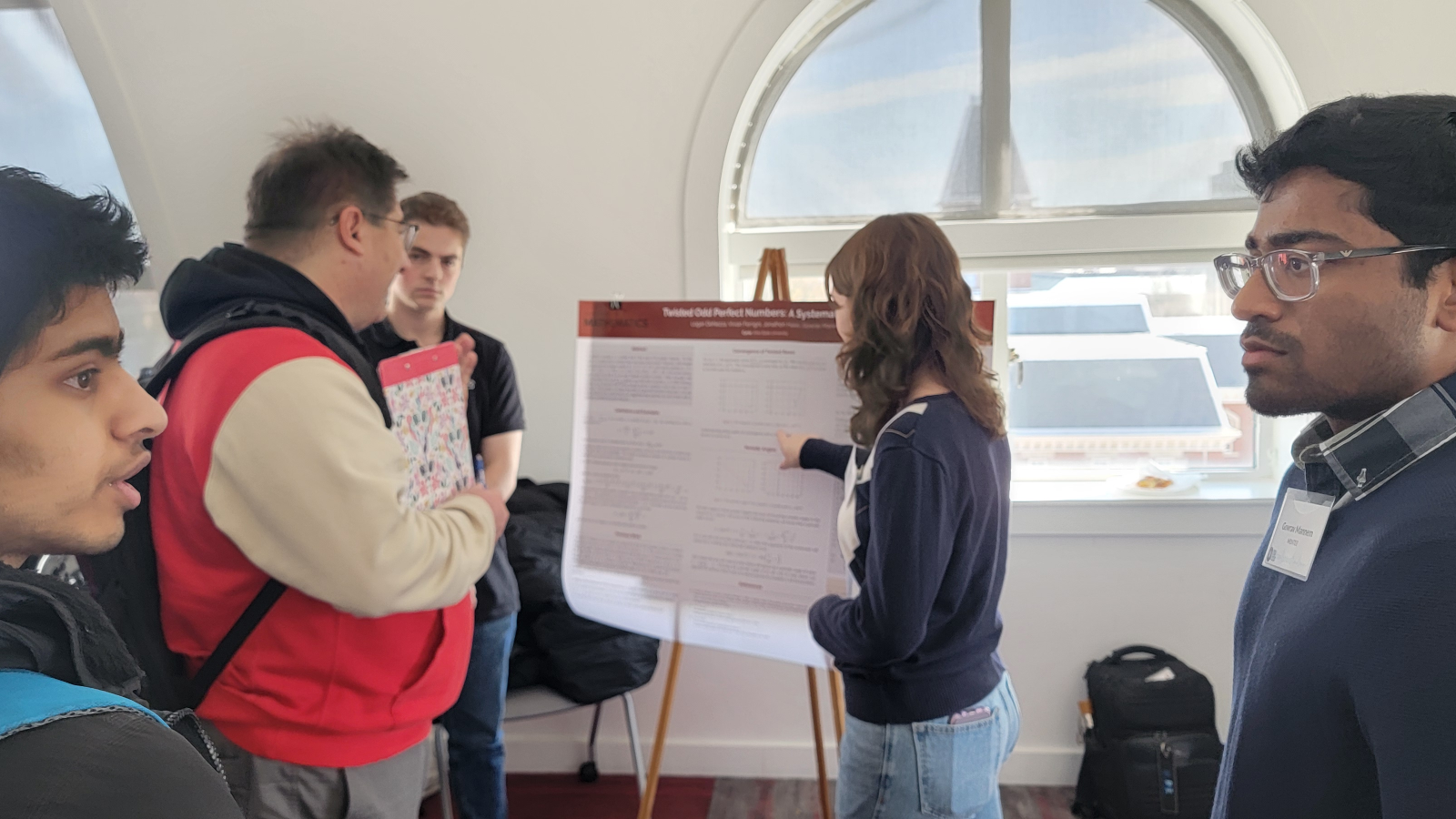 image of students and professors looking at an OSU Cycle poster at the 2024 Cycle conference