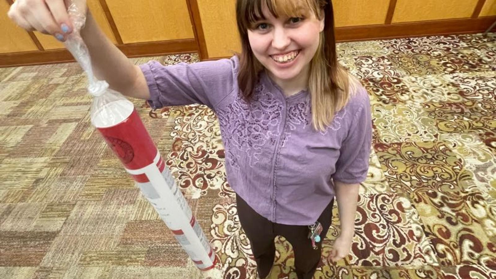 Megan holds a poster like a fish