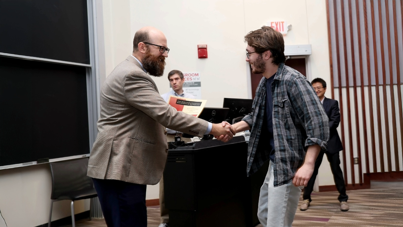 Student and professor shaking hands