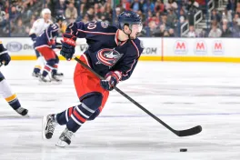 Hockey player with stick on ice wearing Blue Jackets uniform
