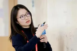 Hong Wang teaching at a whiteboard