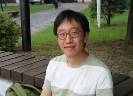 June Huh on outdoor bench
