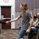 Student shaking hands with professor