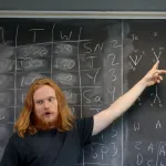 Student pointing at chalkboard