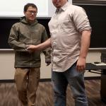 Dr. John Holmes shaking hands with student